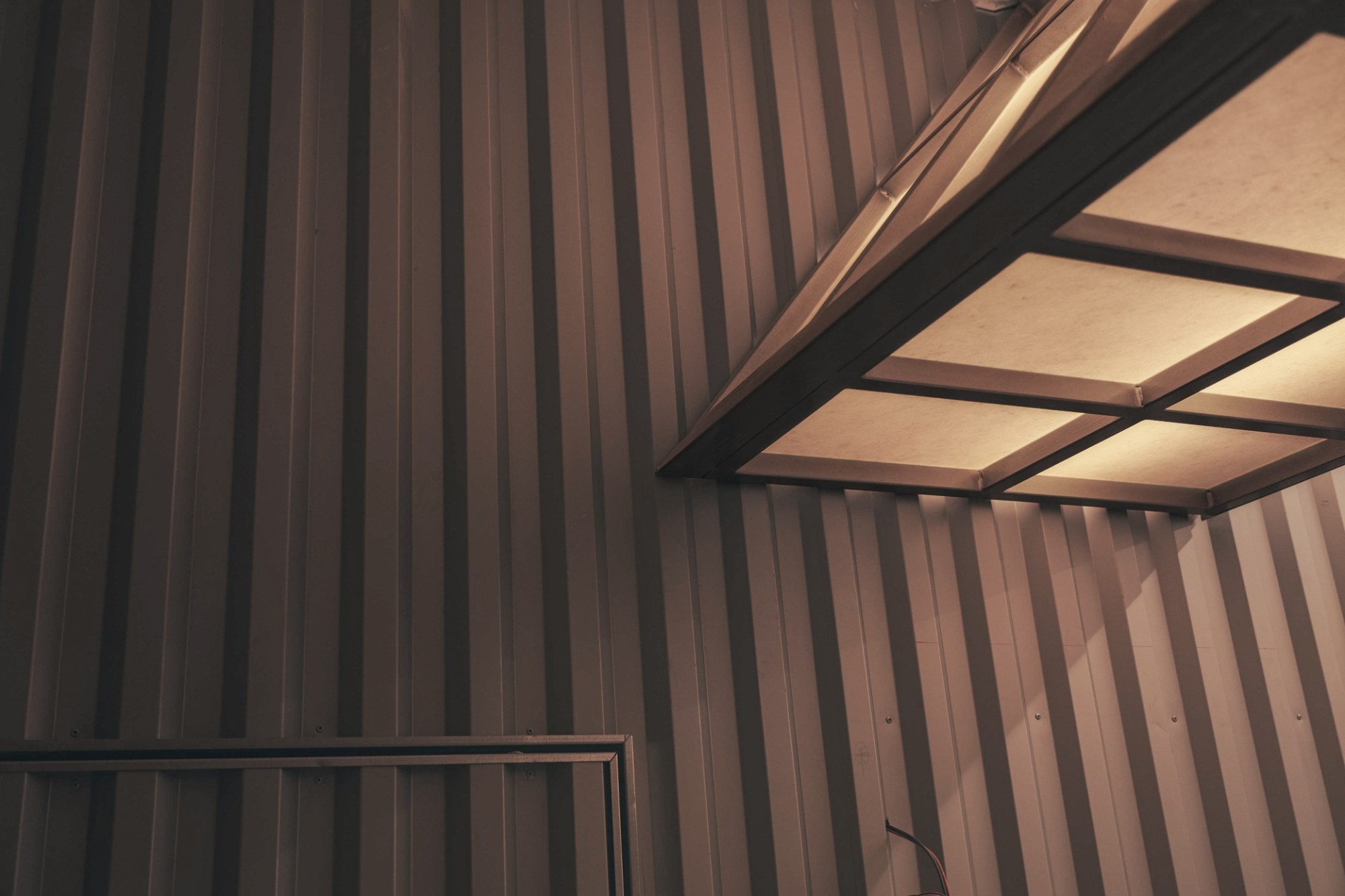 Baan Thai Canteen construction: canopy corner lit against timber cladding